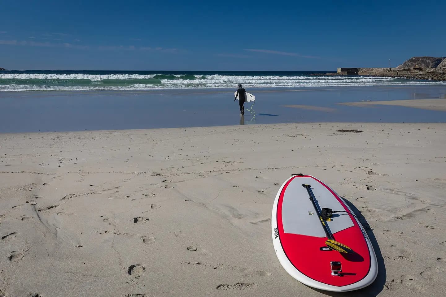 The photograph shows Hoddviksanden beach in Hoddevik on Stadlandet, Stad municipality, Vestland, Norway. The image documents the beach, waves and surfing-related activity at the shoreline