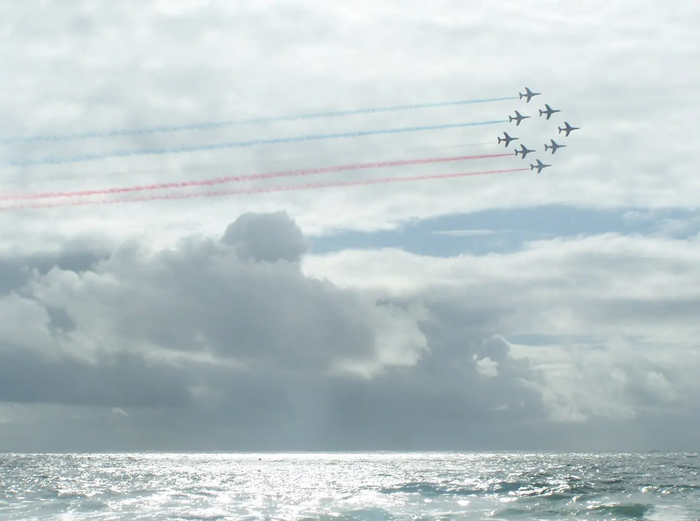 Flight of the Patrouille de France Acrobatic Patrol above the Atlantic ocean just before the coming of a thunderstorm, seen from Lacanau-Océan beach in Gironde , France