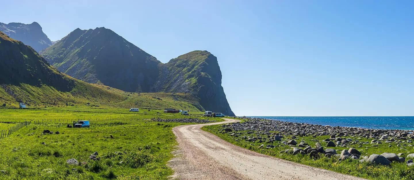 A coastal mountain view at Unstadsjøveien road in Unstad in Vestvågøy, Nordland, Norway in 2022 June. The mountains are Småtindan and Helligberget