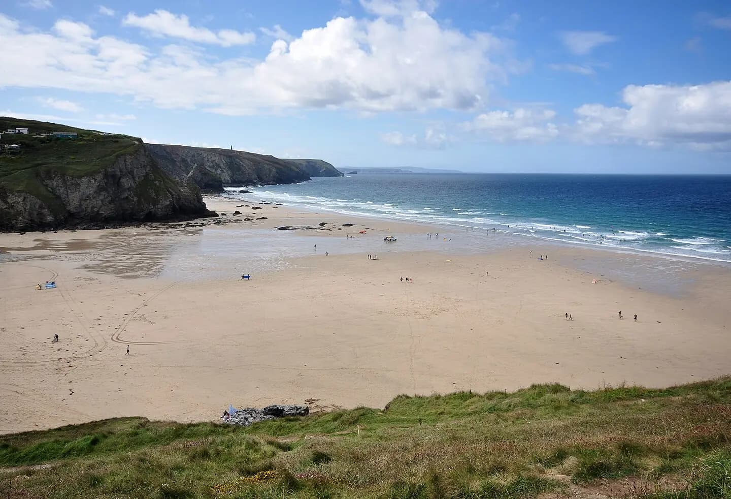 Porthtowan beach in Cornwall, at low tide. The North Cornwall coast stretches towards the Penwith peninsula in the distance