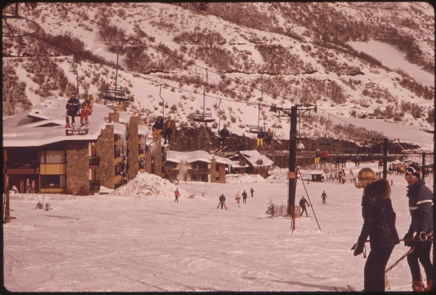 CHAIRLIFT GOES BY CONDOMINIUMS BUILT ALONGSIDE THE SKI SLOPE AT SNOWMASS MOUNTAIN
