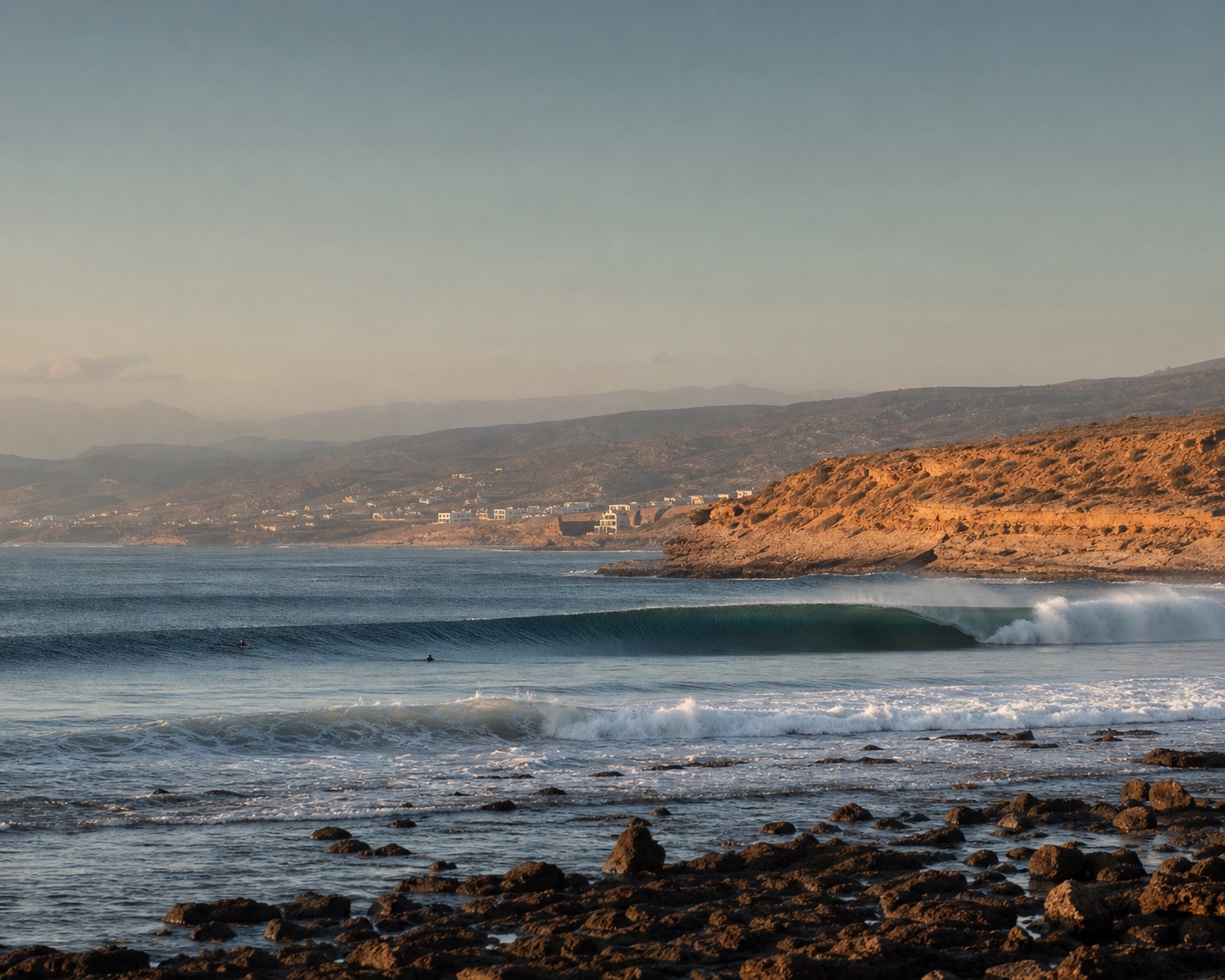 A right-breaking wave peeling beneath Anchor Point's ochre Moroccan headland