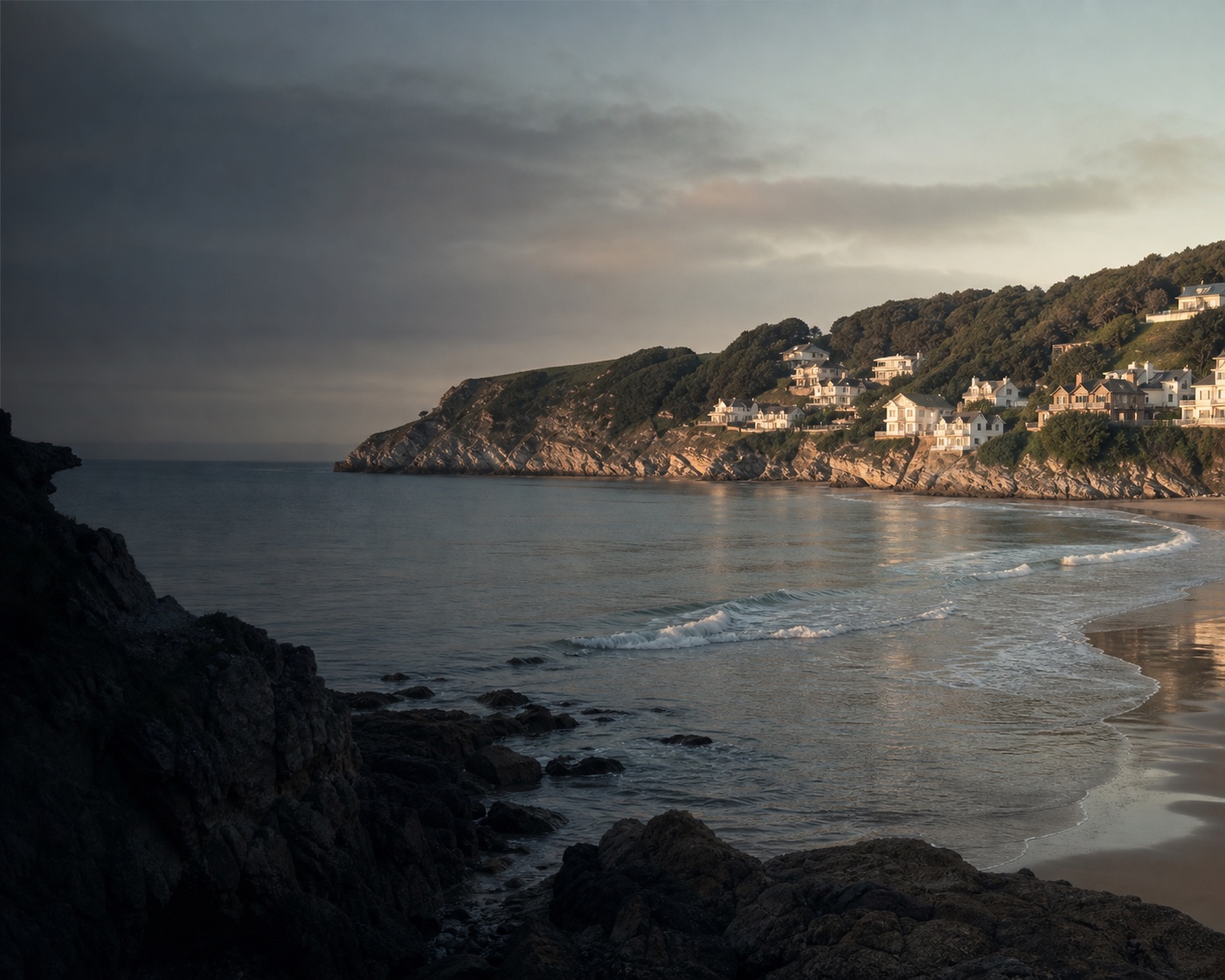 Caswell Bay's horseshoe cove and cliffside homes above clean Gower surf