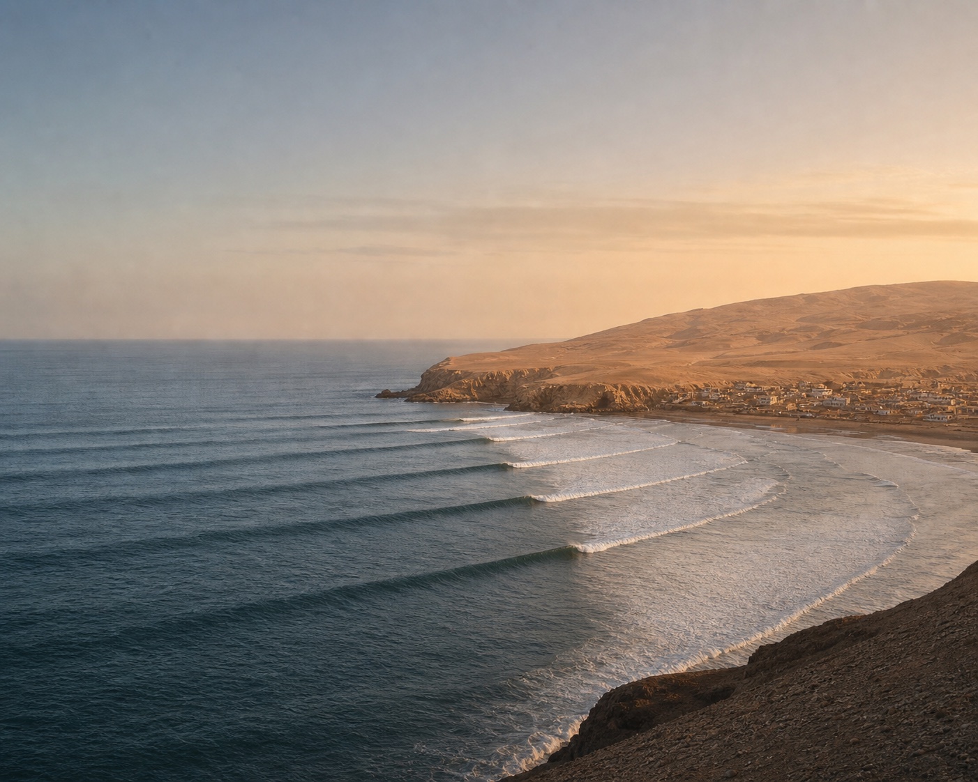 Chicama's long left-hand wave lines peeling past a barren Peruvian desert headland