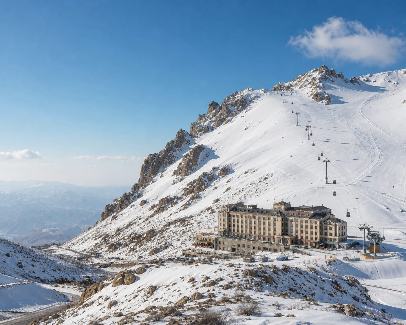Dizin gondola climbing above its high resort hotel in the Alborz Mountains