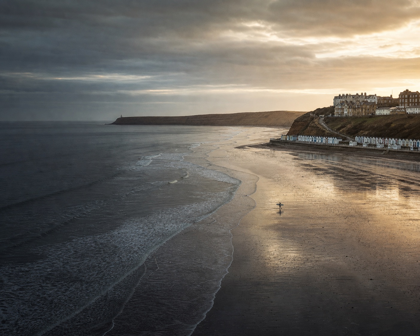 Filey's long sandy bay, beach chalets and the rocky Filey Brigg