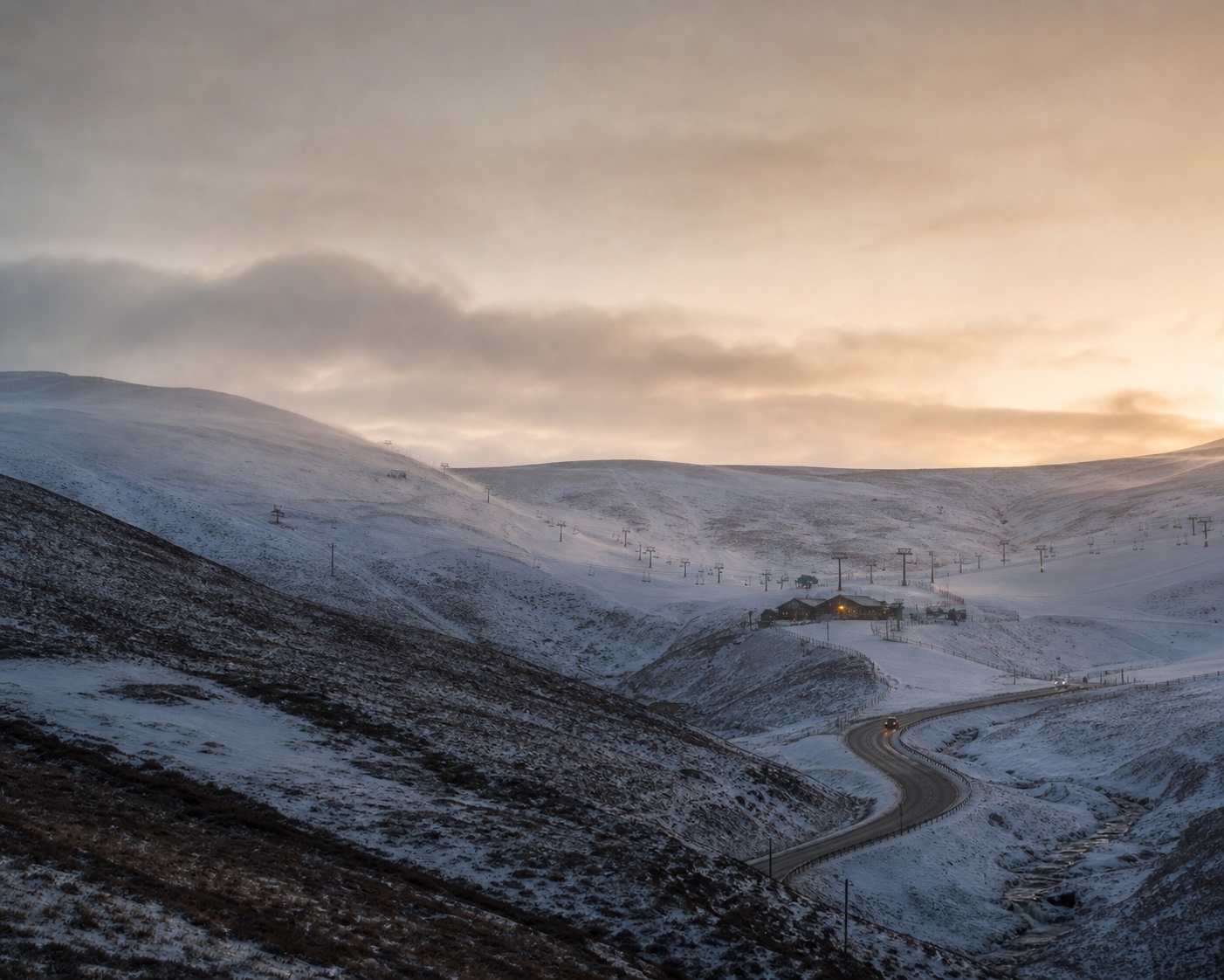 The A93 curling through snowy Cairnwell Pass beneath Glenshee's ski lifts