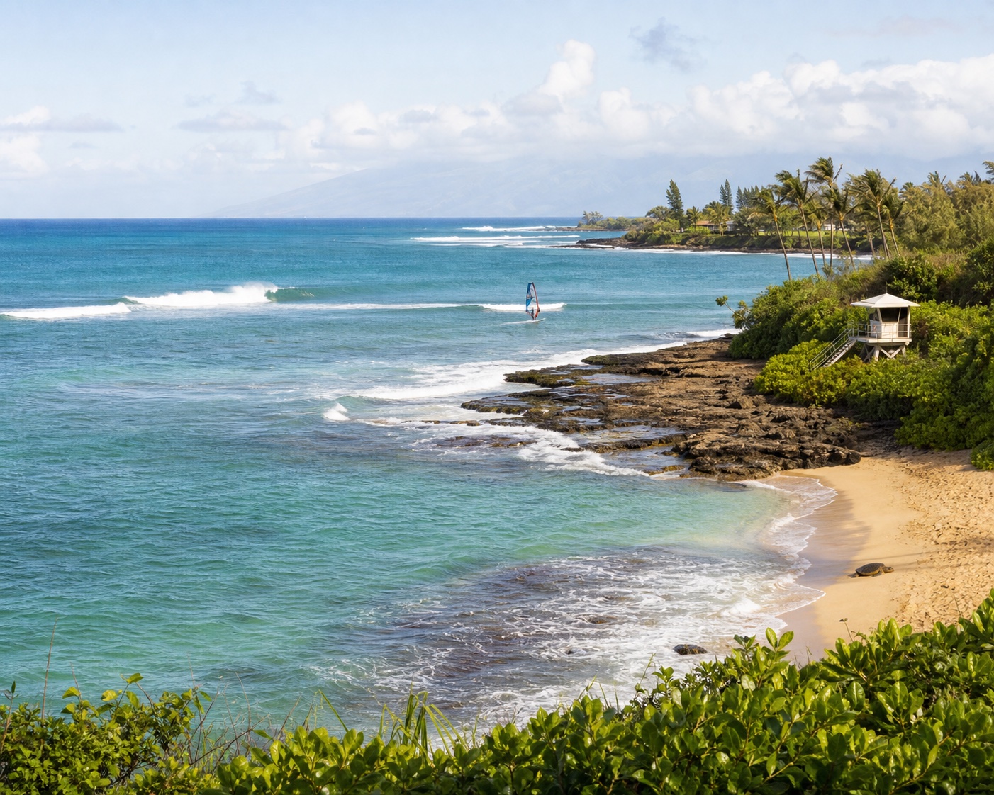 Hookipa's reef surf and windsurfer viewed across its rocky beach park