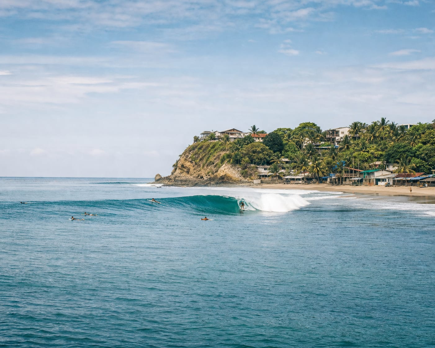 Montañita's point wave wrapping around its green coastal headland