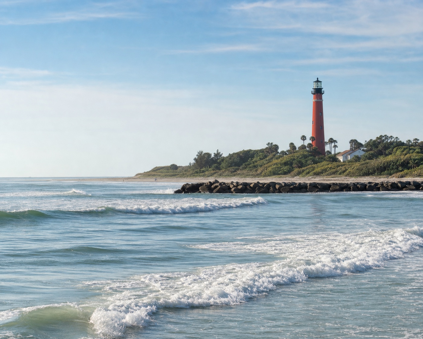 New Smyrna surf below the red Ponce Inlet Lighthouse and jetty