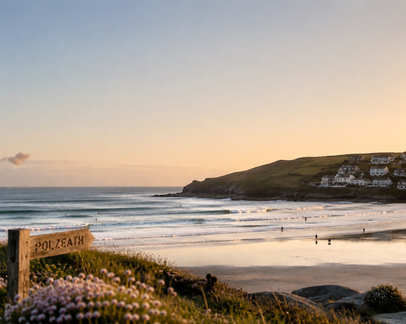 Polzeath beach at golden hour with a wooden Polzeath sign in the foreground
