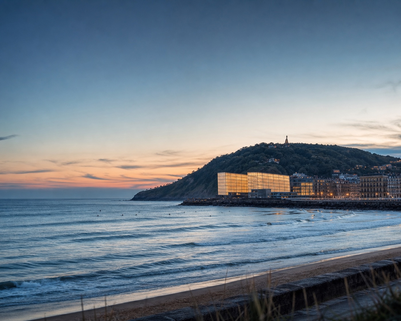 The glowing Kursaal buildings and Mount Ulia beside Zurriola beach in San Sebastián