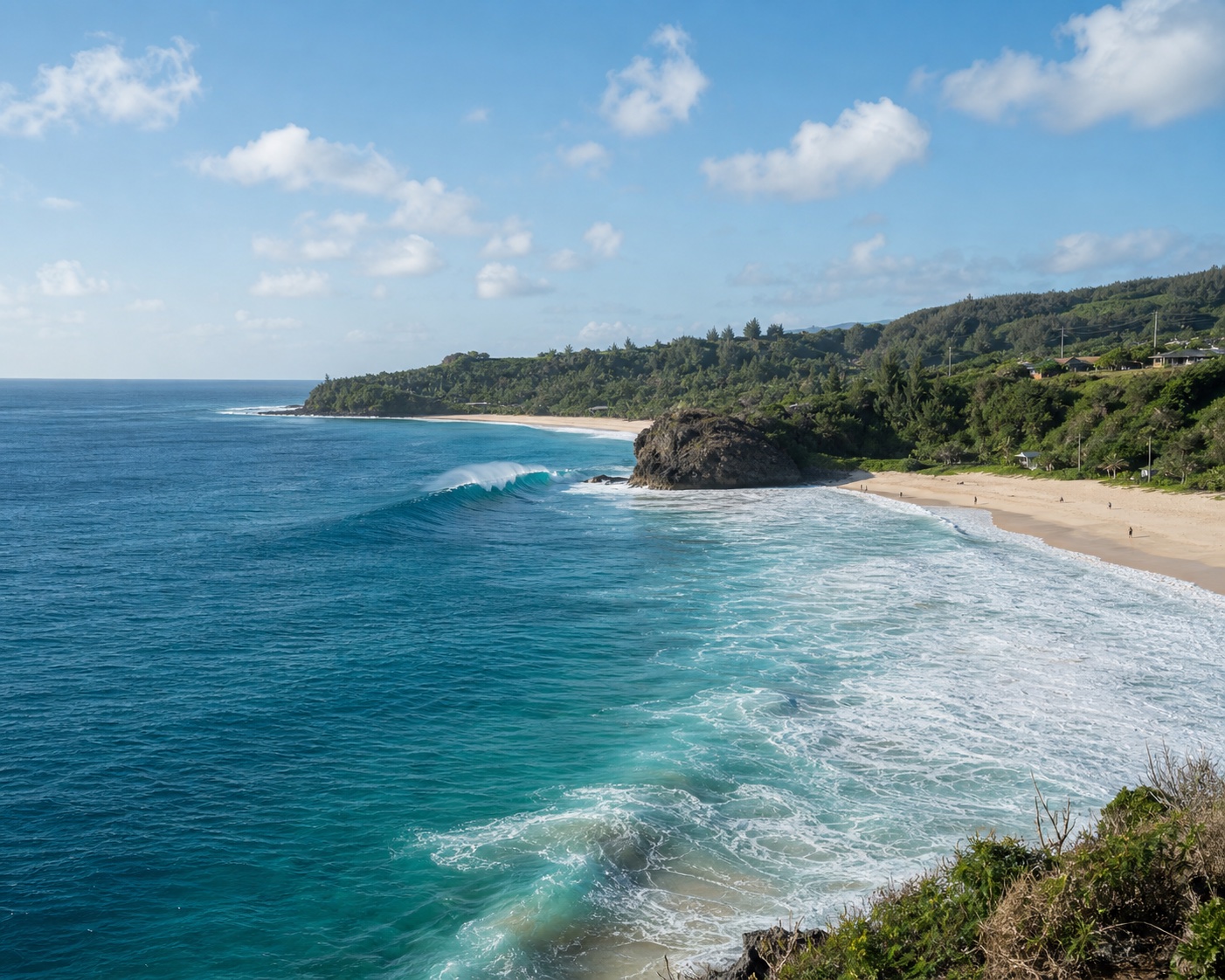 Waimea Bay's blue winter surf and crescent beach beside its jumping rock
