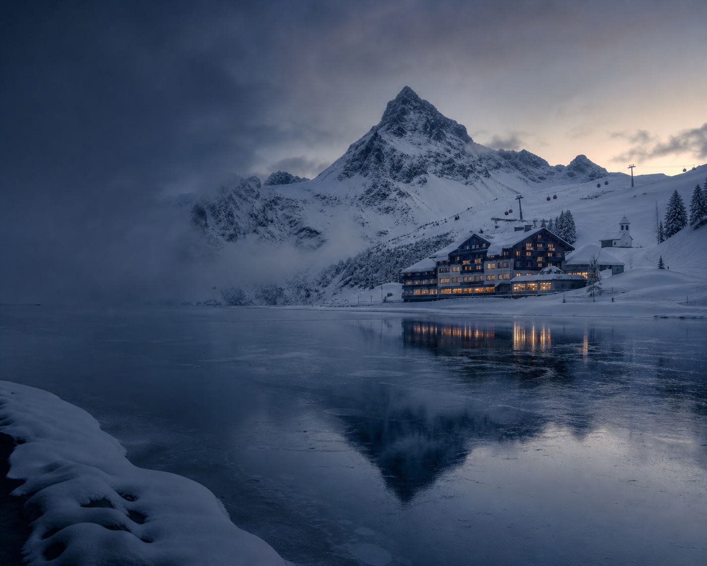 Frozen Körbersee and its mountain hotel beneath the Widderstein