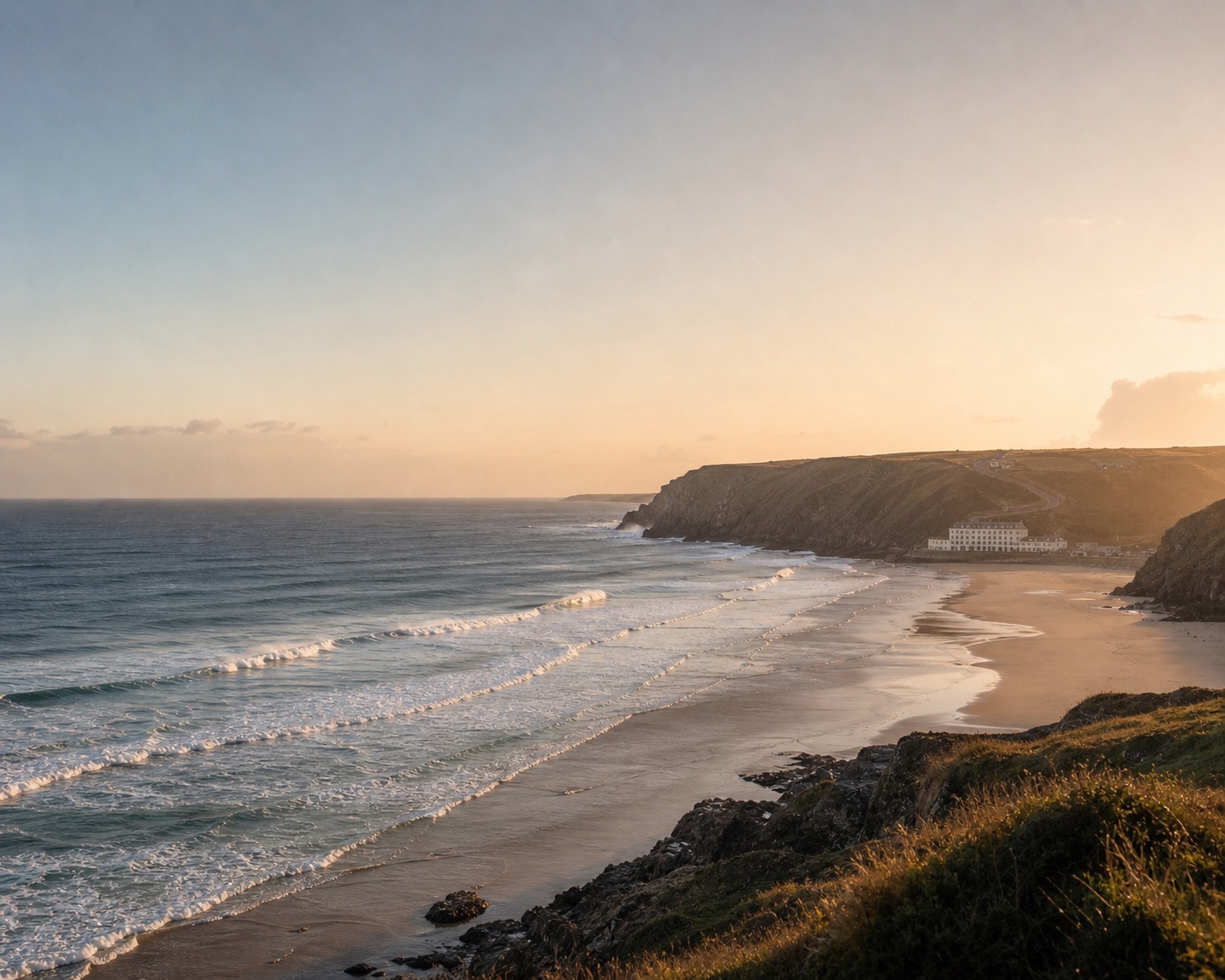 Surf lines sweeping towards Watergate Bay Hotel beneath the Cornish cliffs