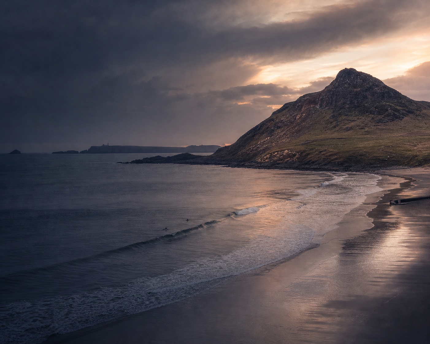 Whitesands Bay surf curving beneath the craggy hill of Carn Llidi